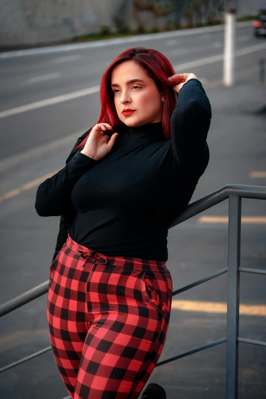 a woman standing on stairs in plaid pants