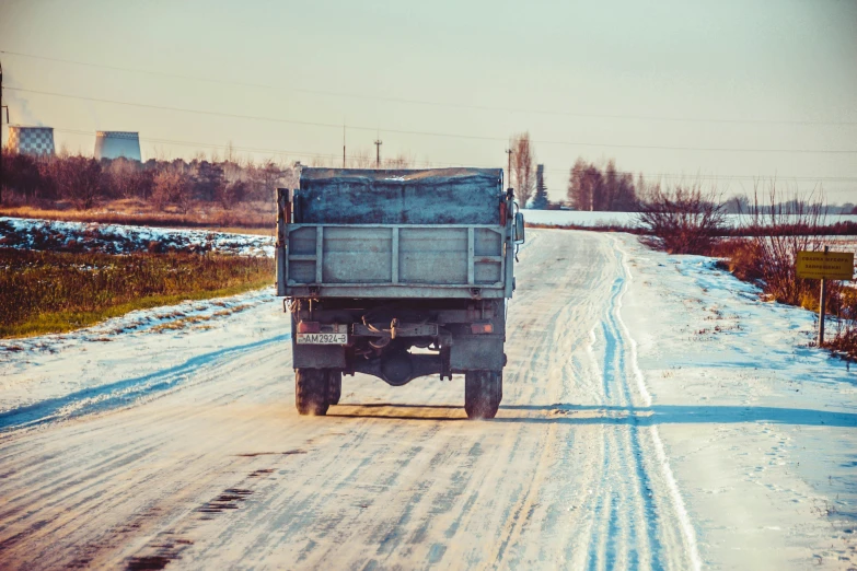 a big truck driving down the street covered in snow