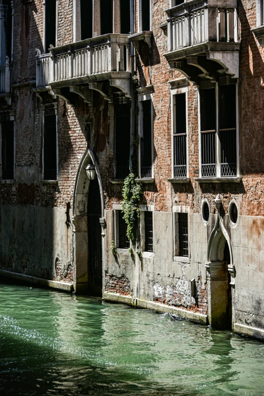 a large old building is next to a small waterway