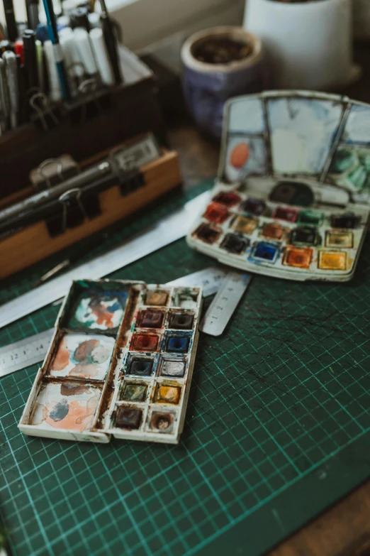 two small trays of colorful paint on top of a table