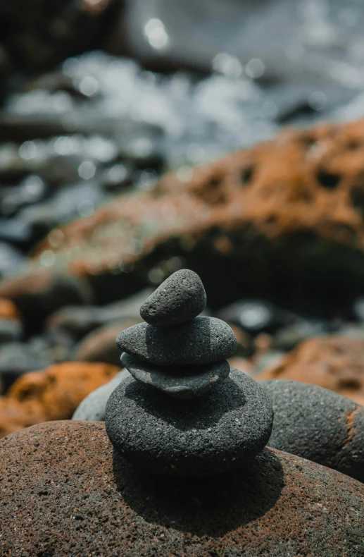 a stack of rocks sits on the rocks by the river