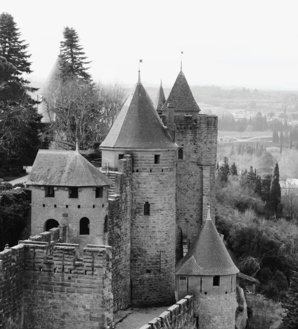 a castle overlooking a city, with mountains in the background