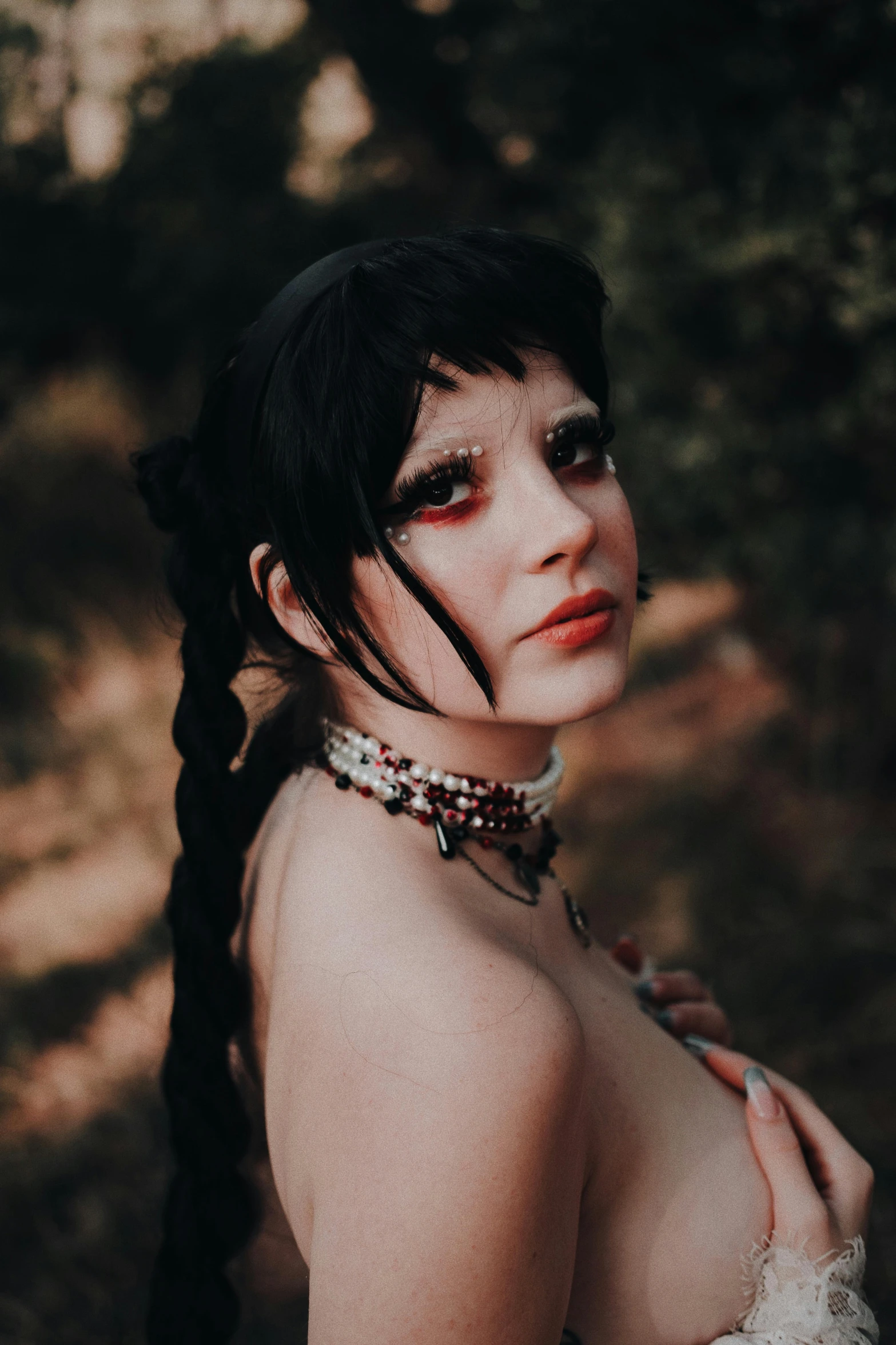 an erotic woman in gothic makeup standing by herself