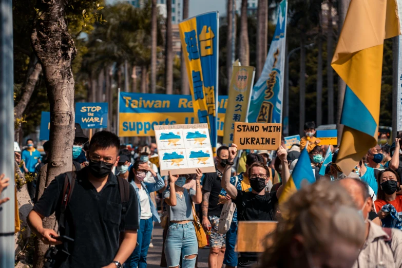 a large crowd of people with signs marching down the street