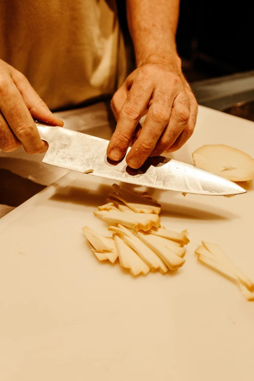 a chef holds a knife  cheese pieces