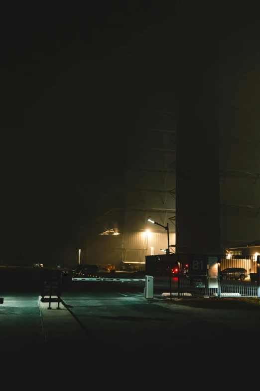 the view from across a street at night with traffic lights in foggy weather