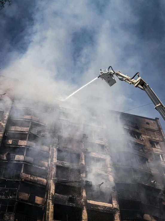 smoke coming out of the ground by a building and a crane