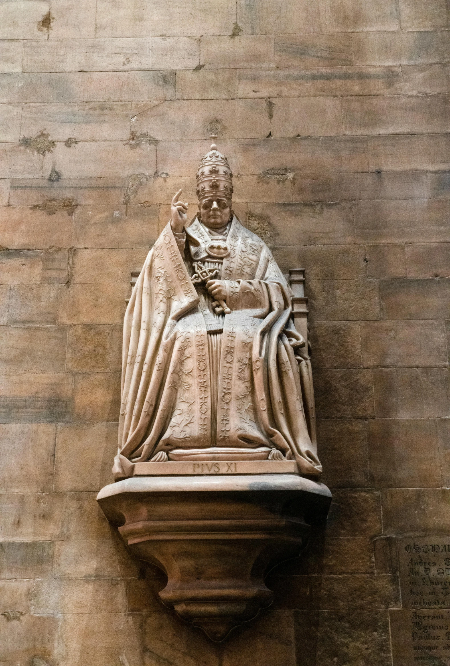 a white marble statue on the side of a wall