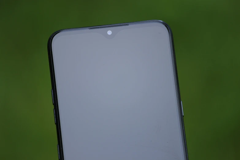 the back side of a white cell phone against a green wall