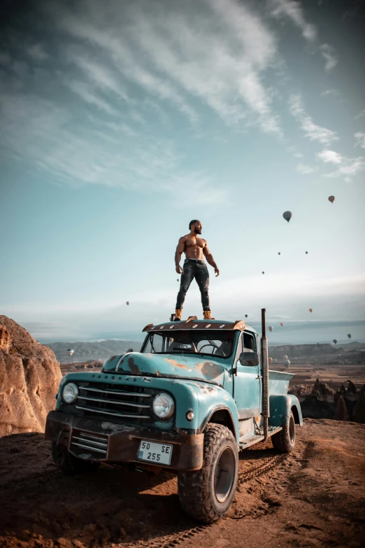 an older truck with a man standing on top