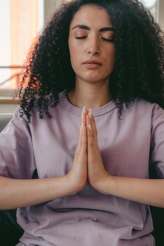 a woman with her eyes closed as she is meditating