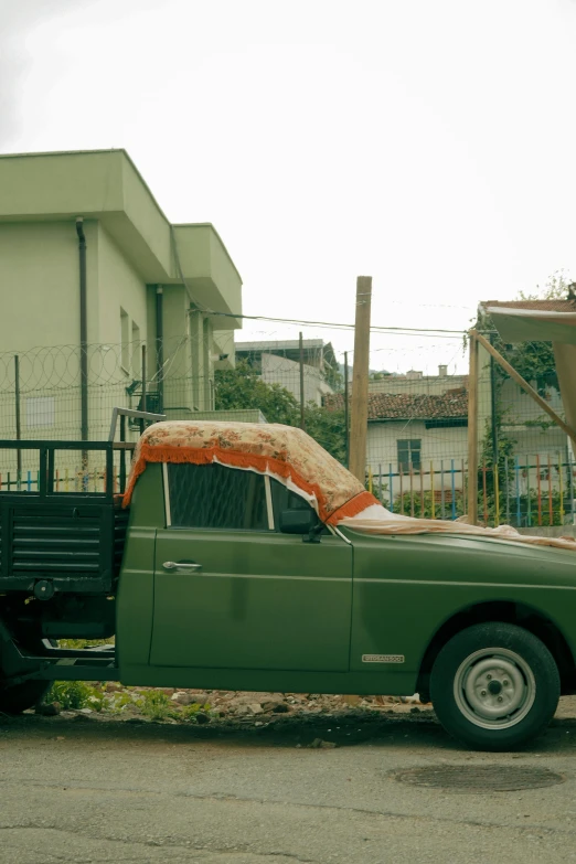 the green truck is loaded with an orange blanket