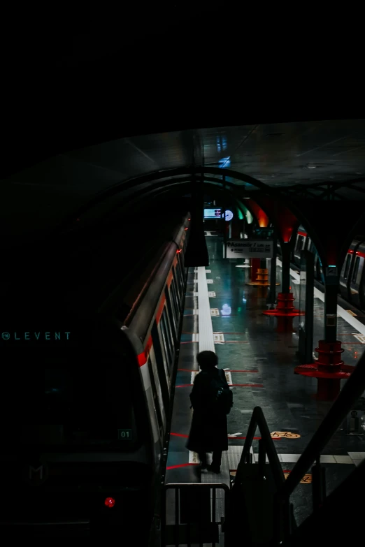 a person standing by the railing waiting for a train