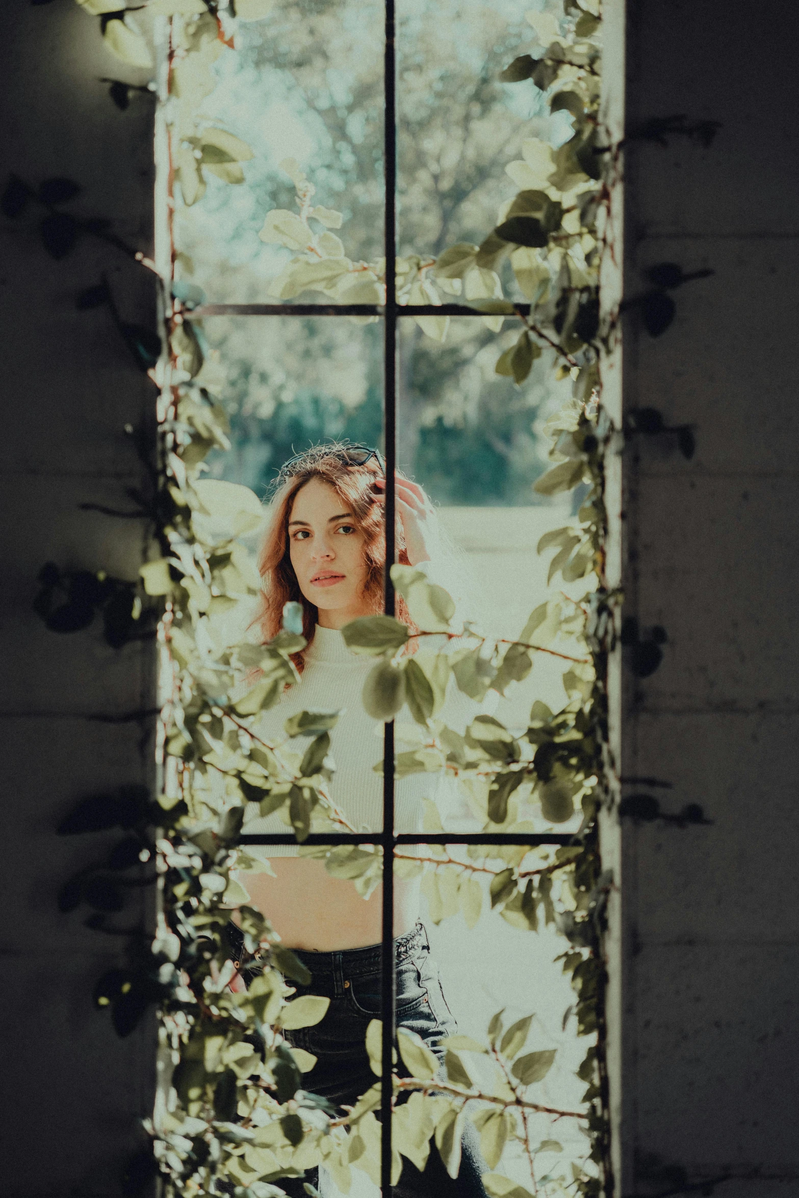 a woman looking out the window of a white building