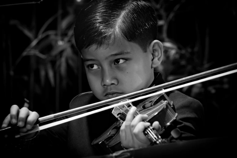 a child holding a violin playing on a strings