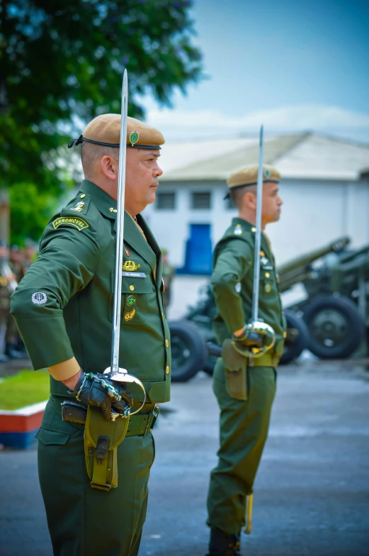 two men are dressed in military uniforms holding swords