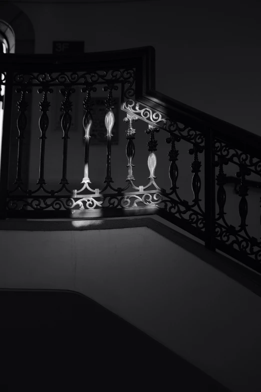 a pair of black and white stairs with a light going down them