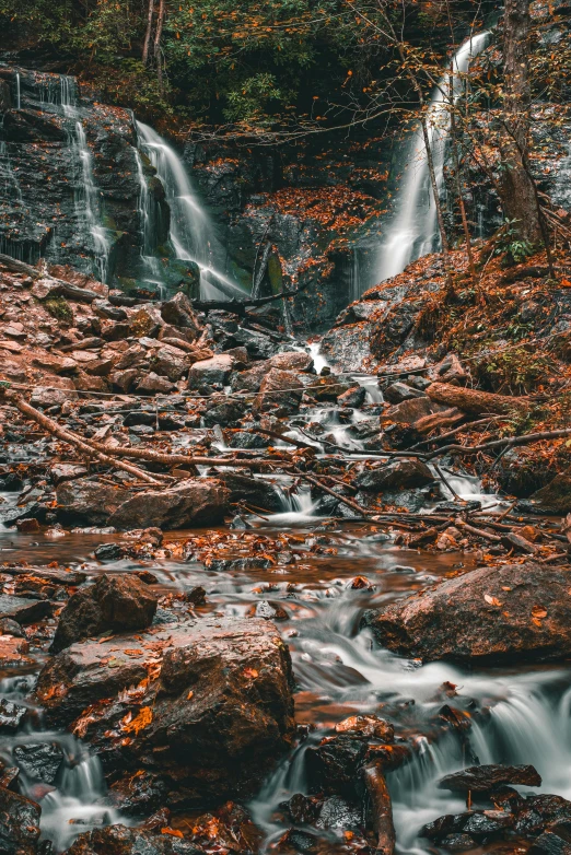 a waterfall in the woods with lots of rocks