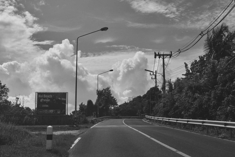 an empty street near power lines and trees