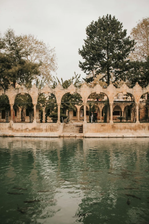 people sitting on a pavilion next to a large body of water