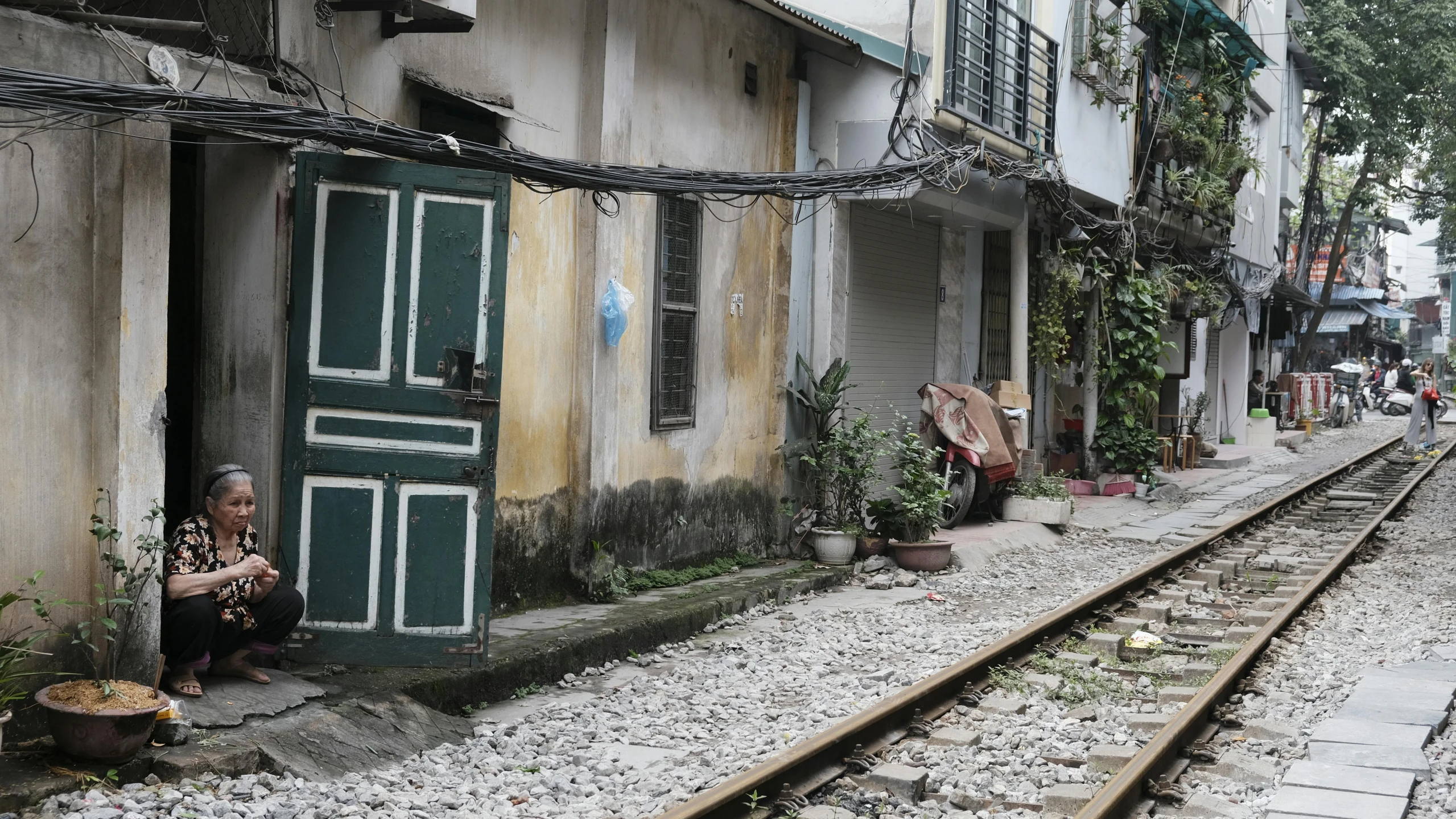 a woman sitting in the doorway of an old building