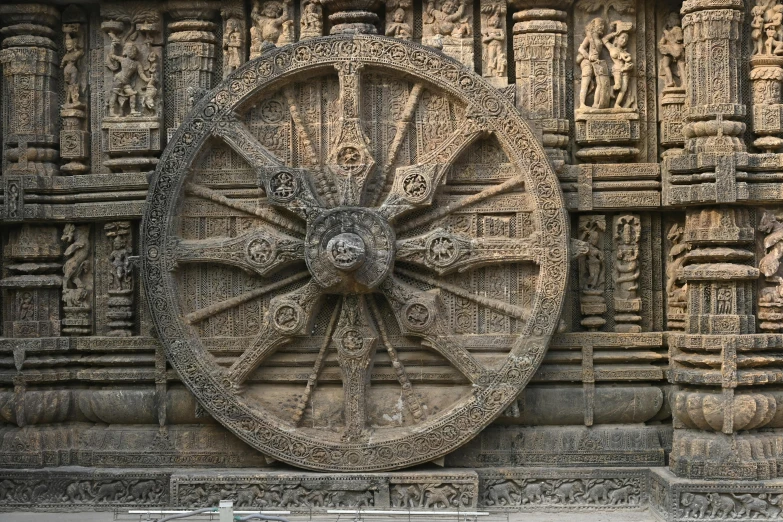 a big wooden wheel that is sitting on the wall