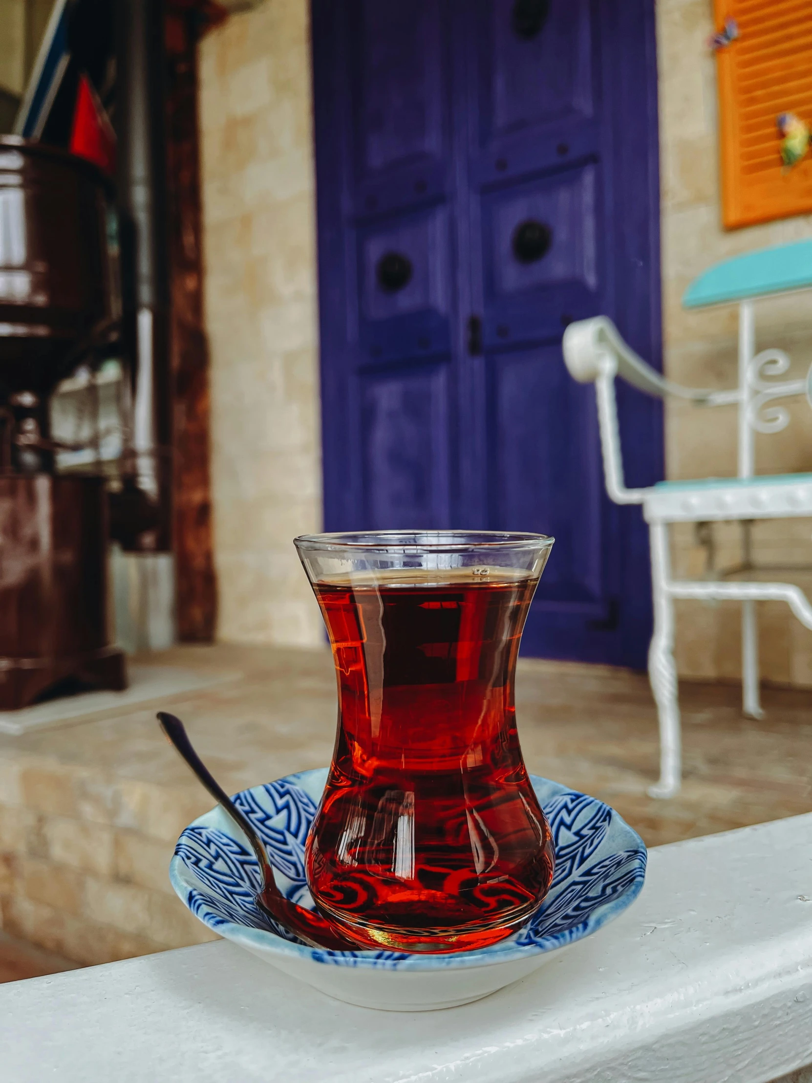 the glass cup with a spoon is sitting on a plate