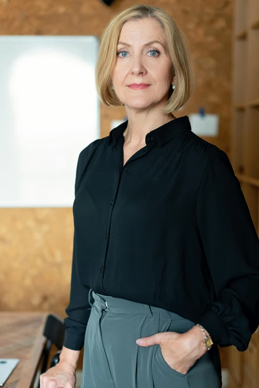 a woman poses for the camera in front of a board