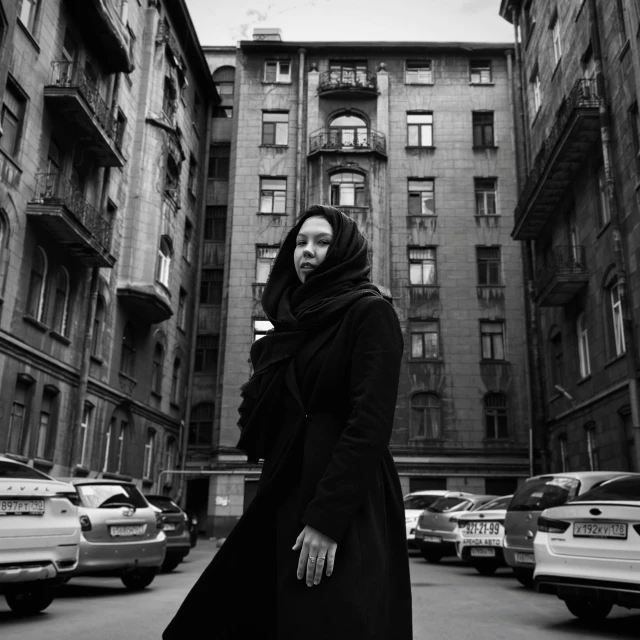 a woman in black standing in the middle of an old city