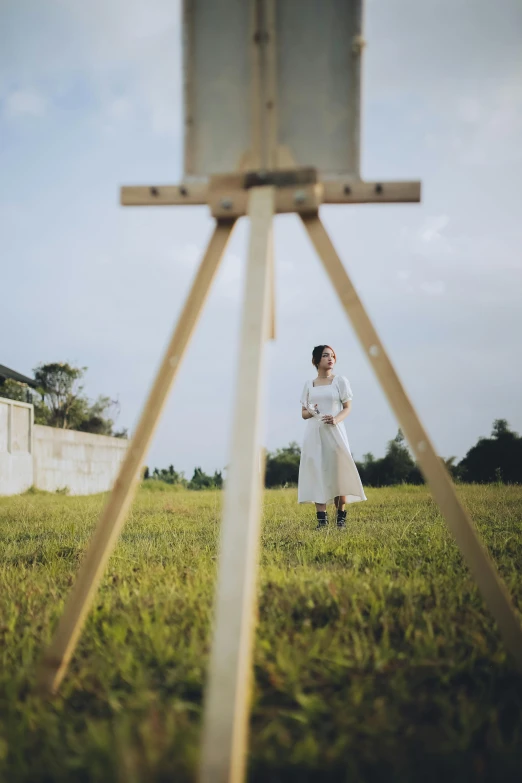 a woman dressed in a white dress is walking through the field