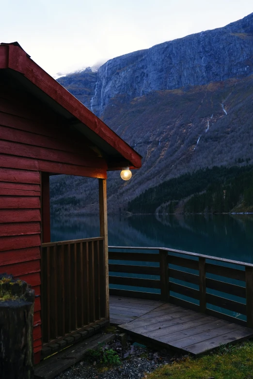 a house with a light on next to the water