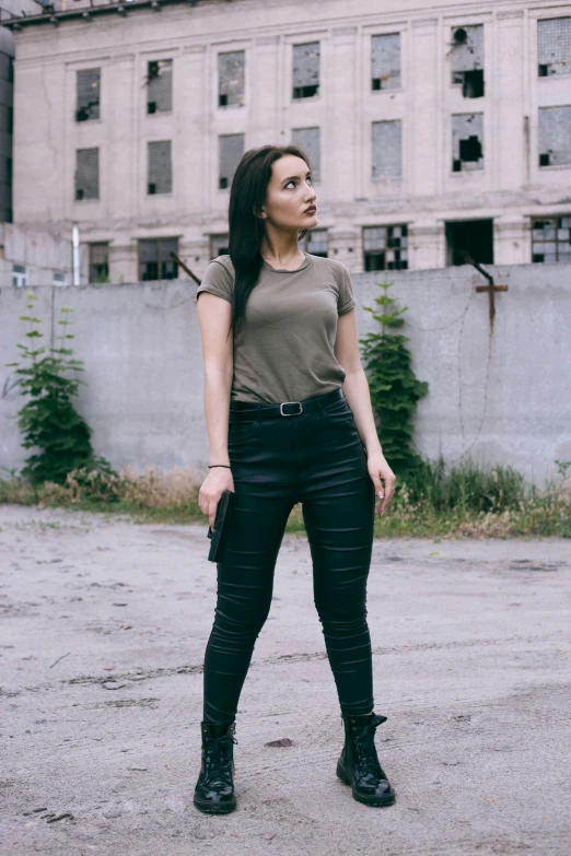 the woman stands next to an old building