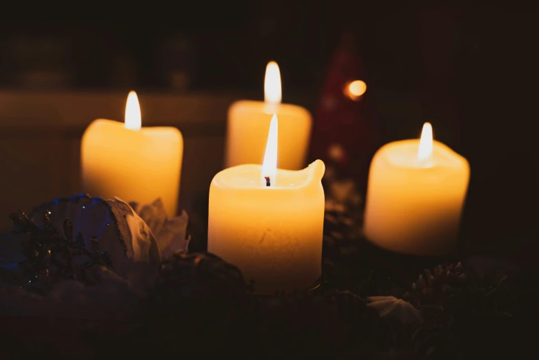 a group of lit candles sit on top of a table