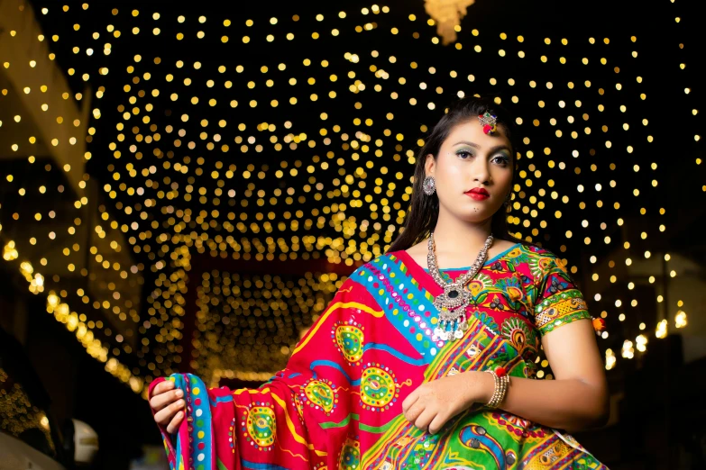 a woman dressed in colorful sari posing for a pograph