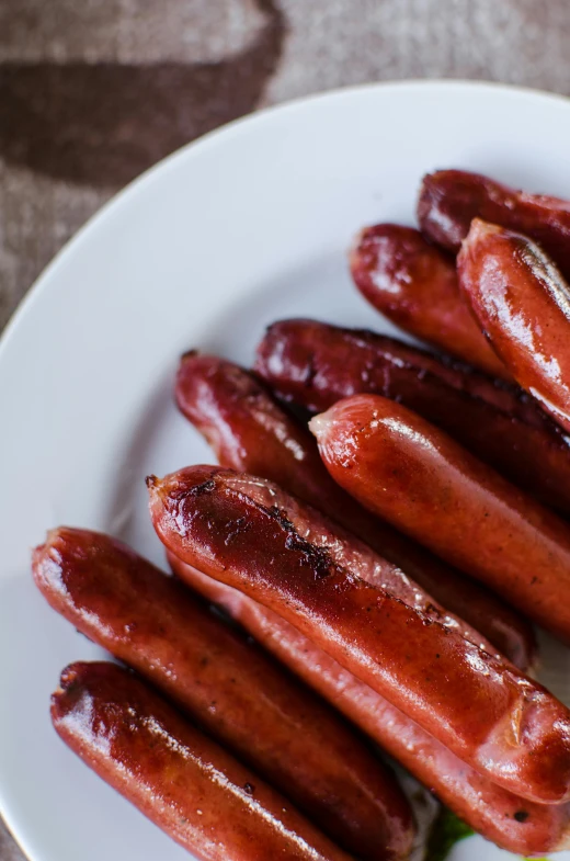 several cooked dogs are stacked on a plate