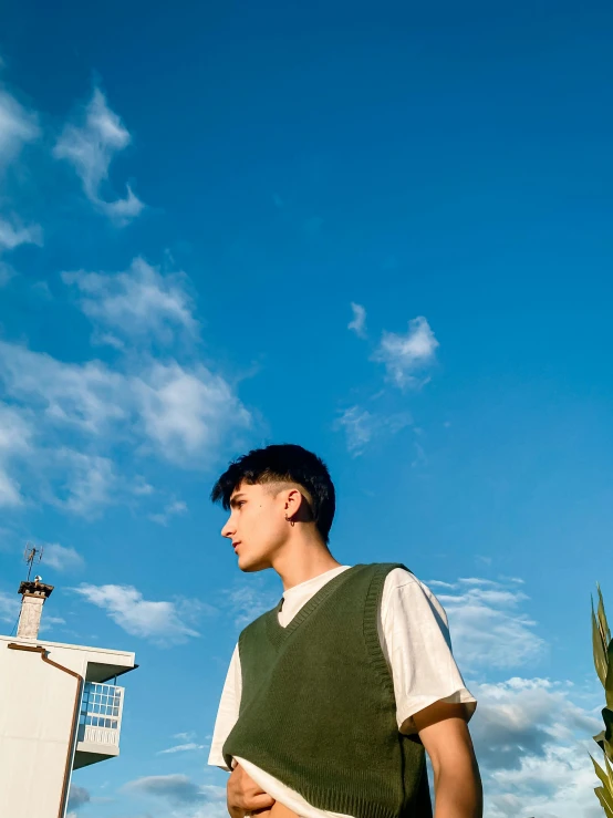 a young man posing with a sky background