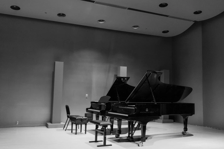 a black grand piano in a room with a chair and table