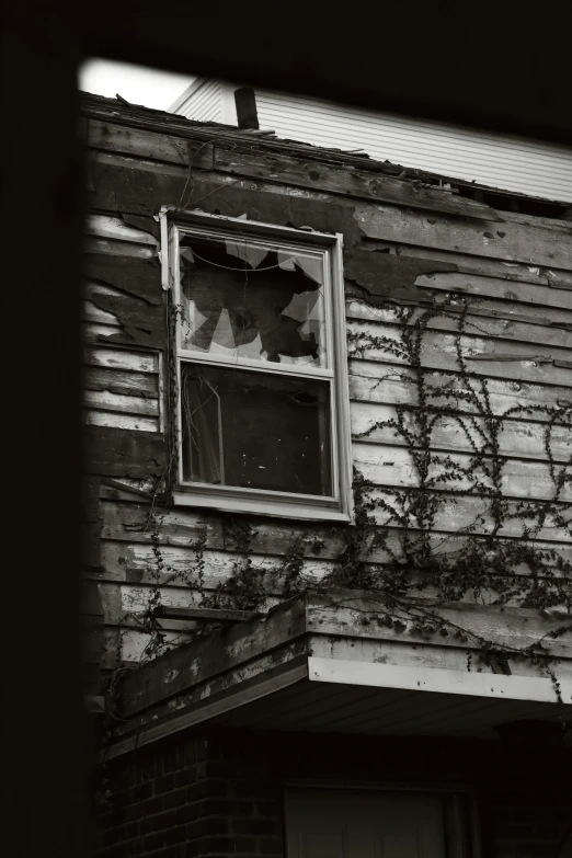 an open window on the side of a run down house