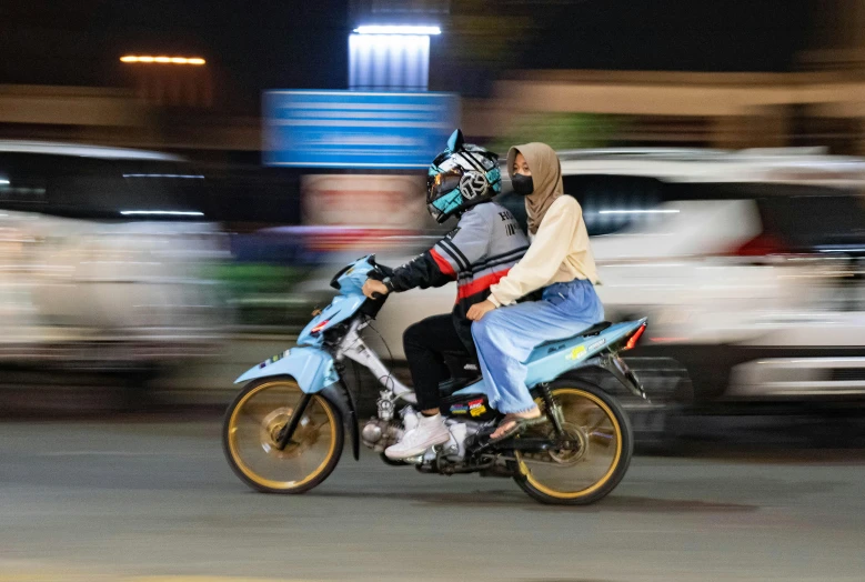 the two people are riding a motor cycle