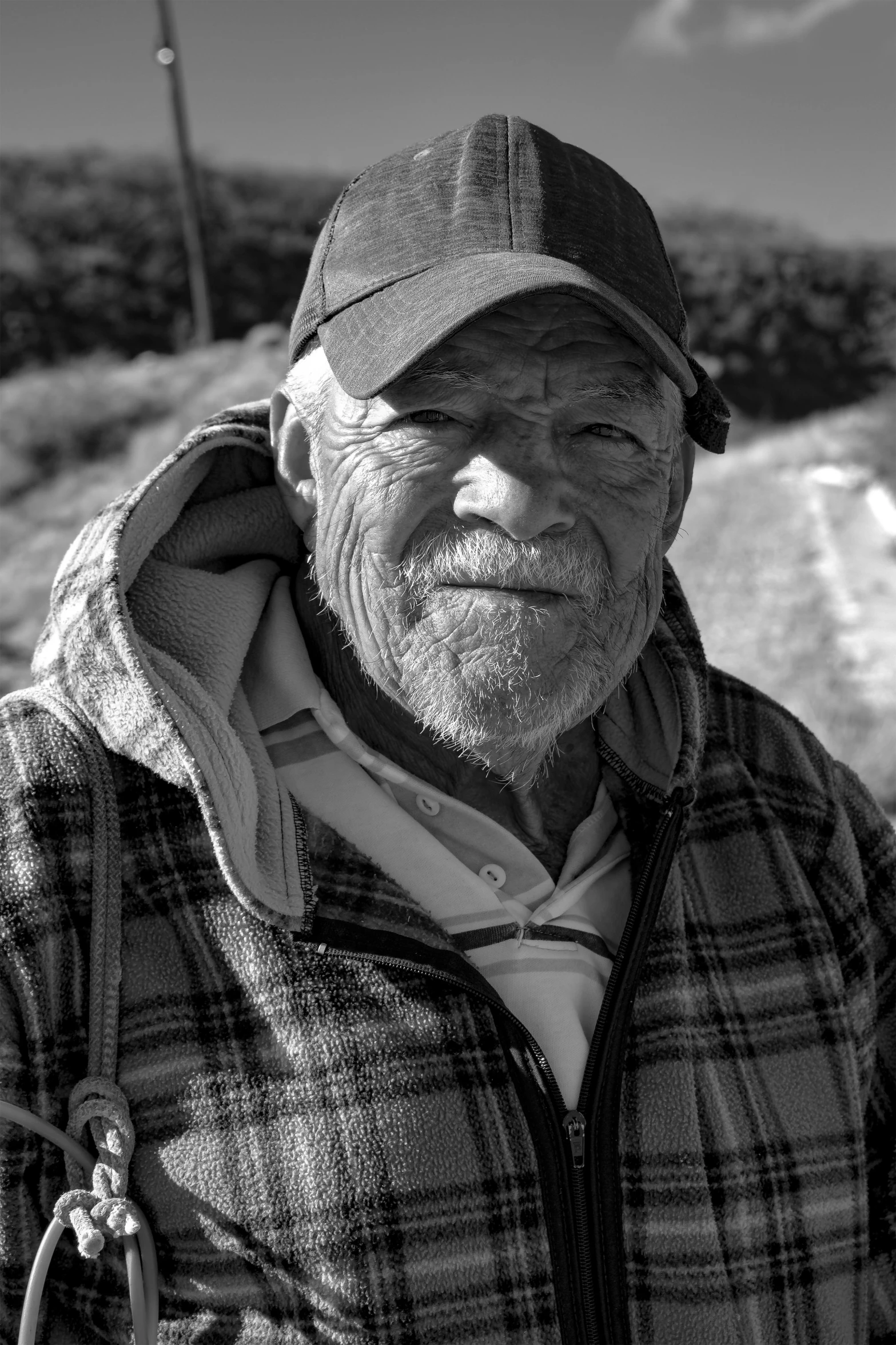 black and white po of man with plaid coat and hat