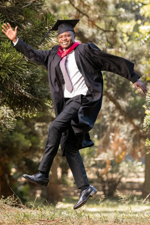 an image of a male graduate jumping