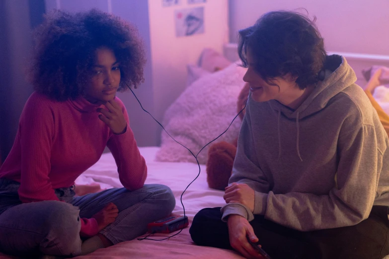 an adult and a child sitting in front of a bed