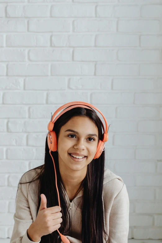 a woman wearing ear muffs is giving the thumbs up sign