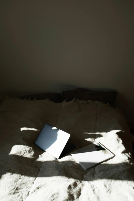 a messy bed with a book on the comforter