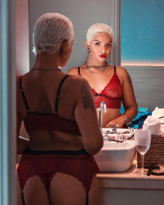 a woman is dressed in lingerie looking into the mirror