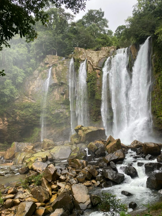 waterfalls are visible in the foggy air as the water flows over rocks