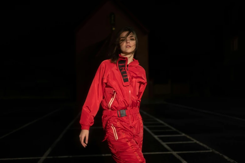 a model is wearing a red suit and sneakers