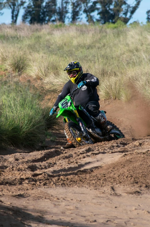 a man riding on the back of a dirt bike on a dirt road