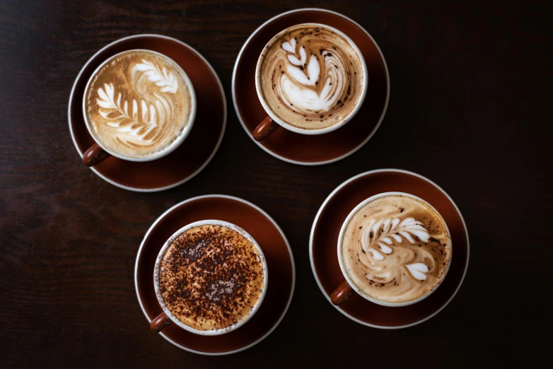 four cups with different designs in them sitting next to each other