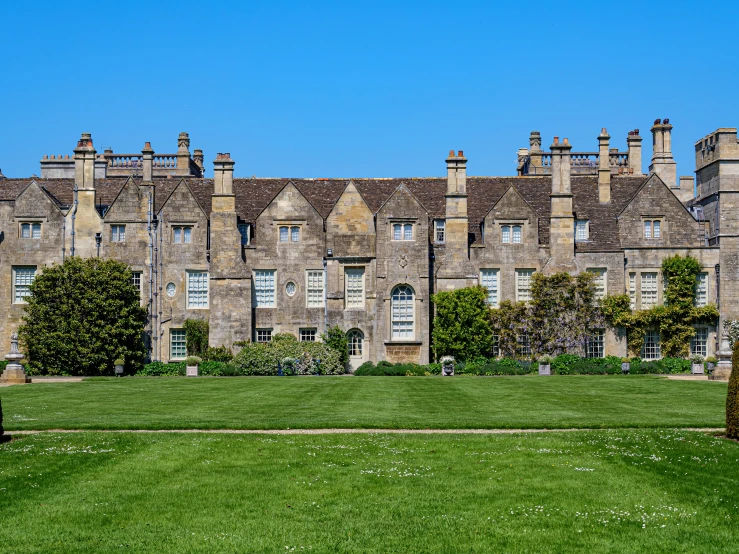 the front view of an old stone house with a big lawn